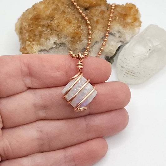 rainbow moonstone in copper wire in hand