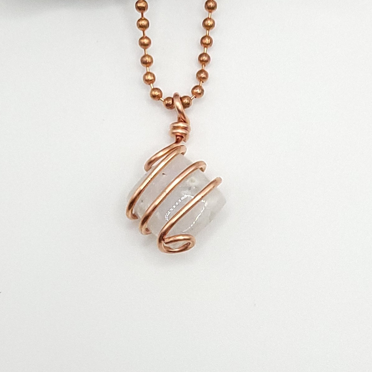rainbow moonstone in copper wire on white background