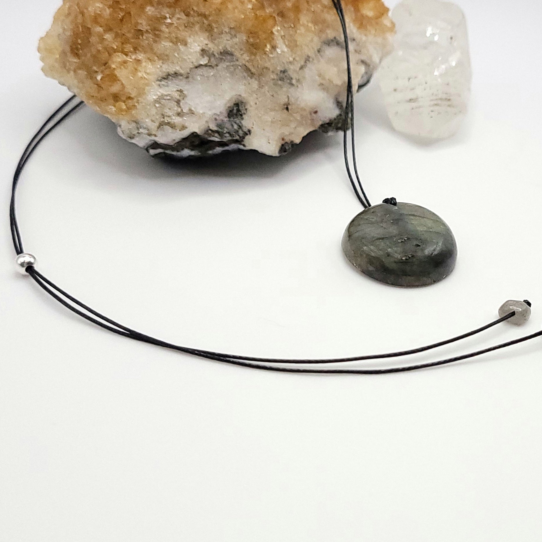 An adjustable Labradorite crystal necklace with a black waxed cotton cord, a sterling silver sliding bead, and a second crystal bead - side view