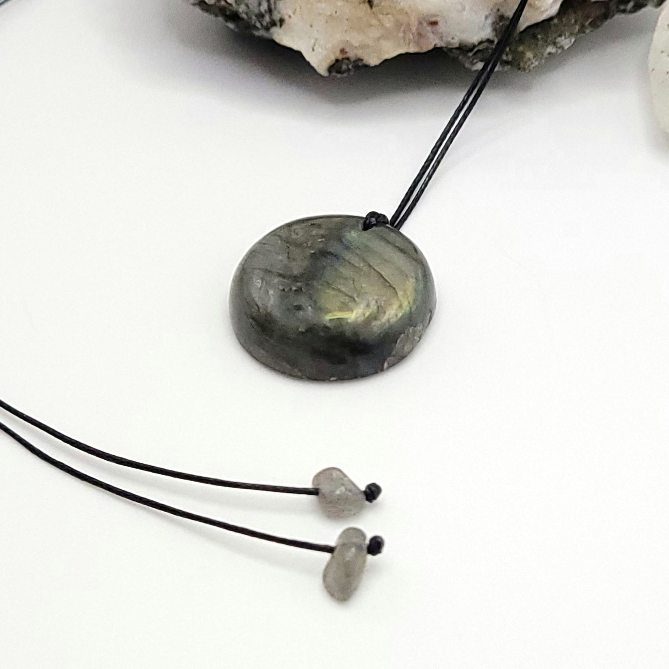 An adjustable Labradorite crystal necklace with a black waxed cotton cord, a sterling silver sliding bead, and a second crystal bead - side view