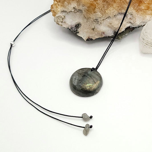 An adjustable Labradorite crystal necklace with a black waxed cotton cord, a sterling silver sliding bead, and a second crystal bead.