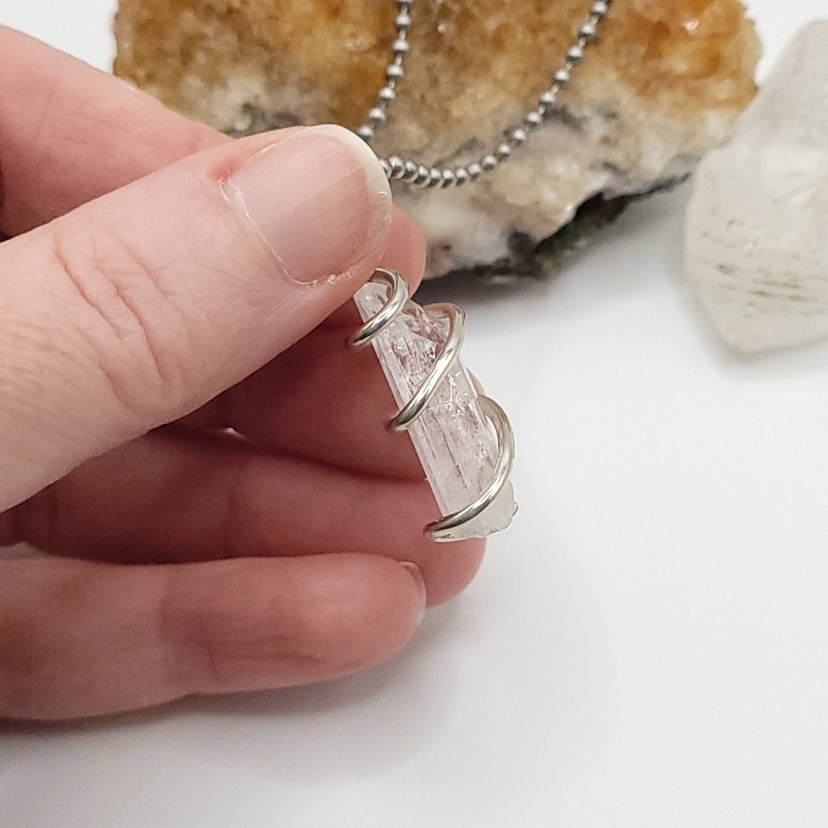 Raw Danburite Necklace in Silver side view in hand