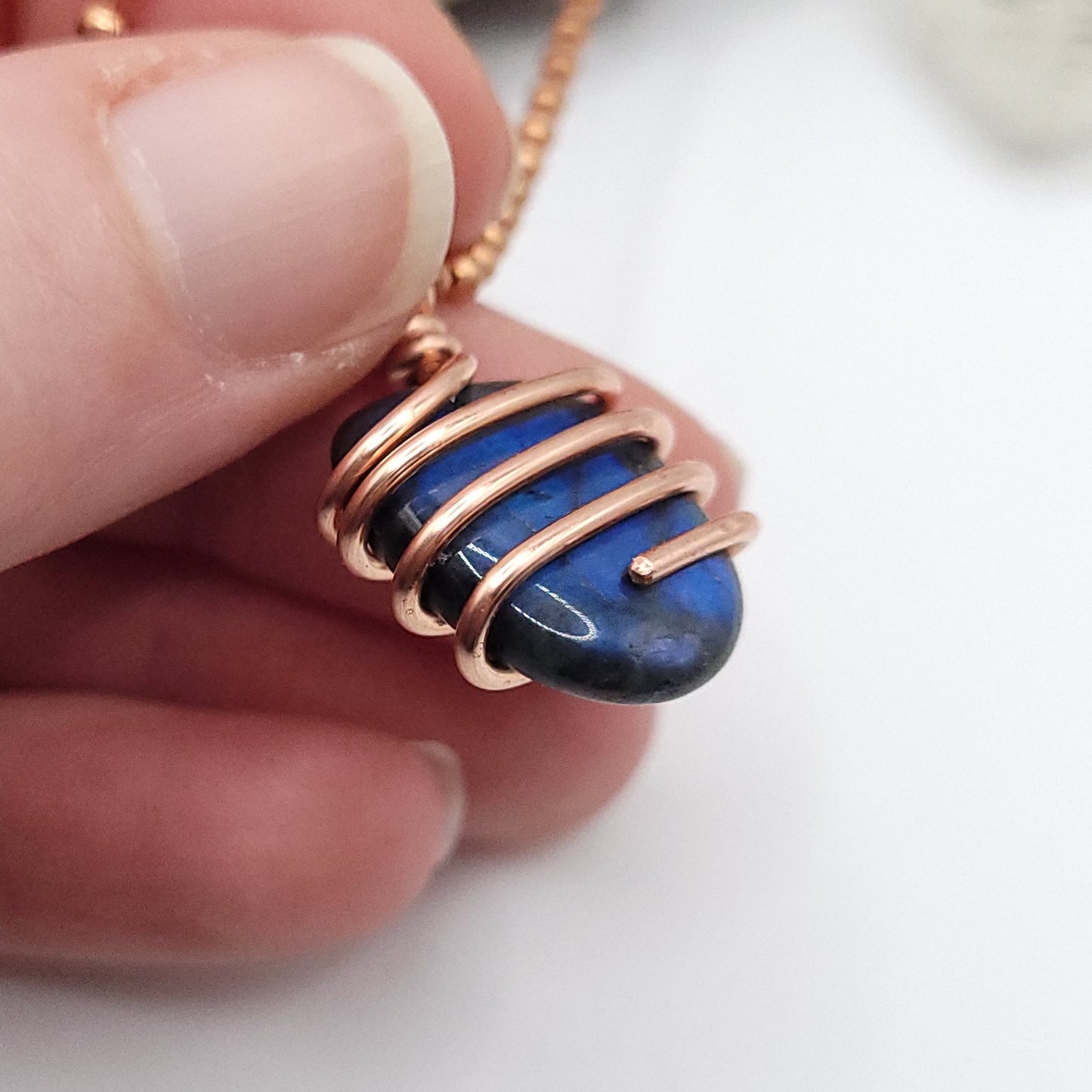 labradorite necklace in copper held in hand