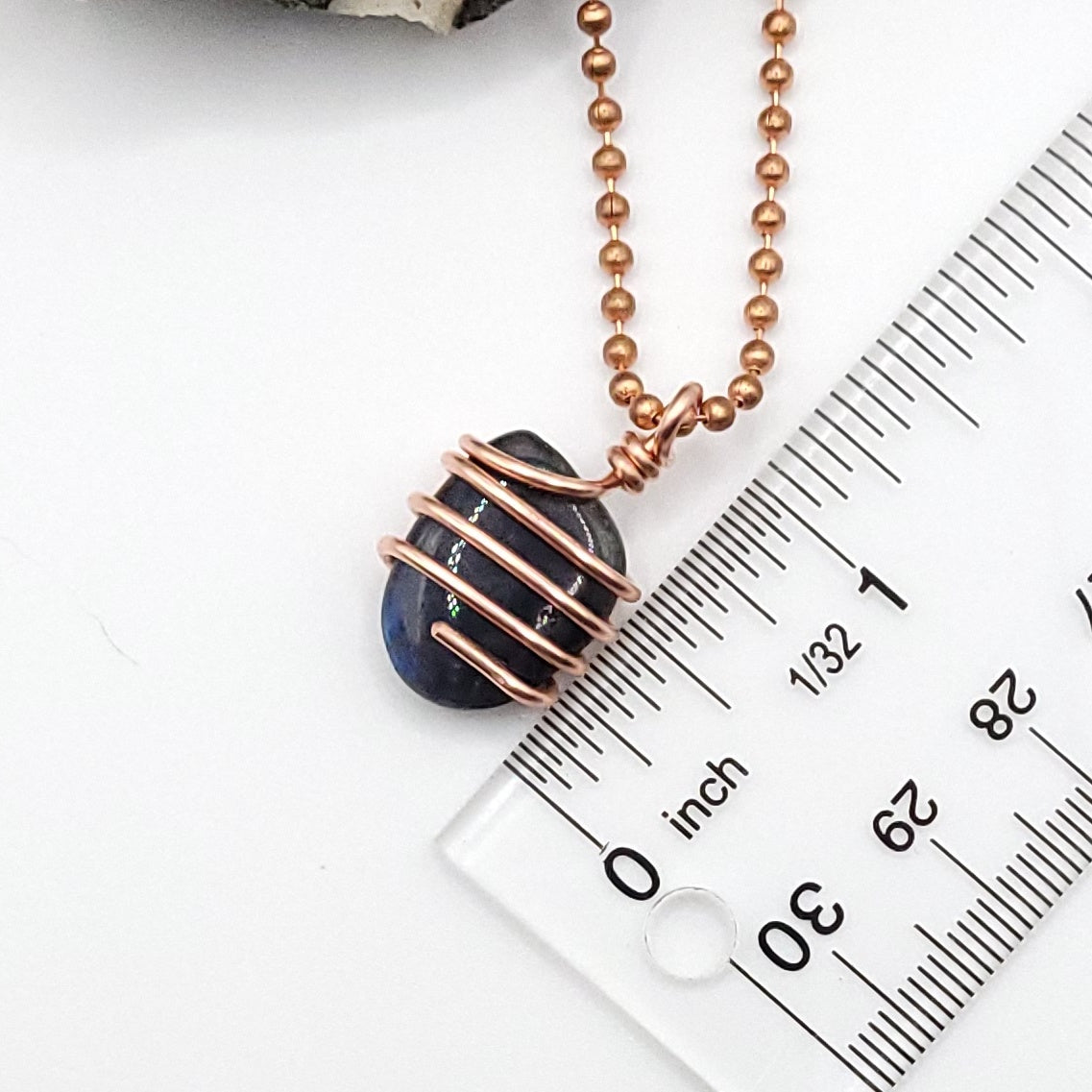 labradorite necklace in copper next to ruler measuring about 1 inch