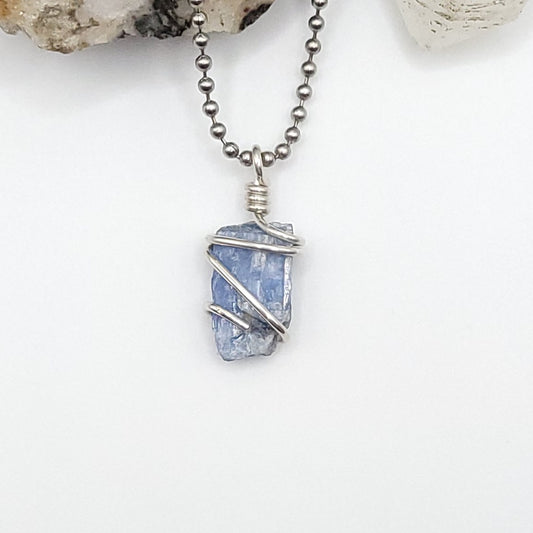 raw blue kyanite necklace in silver wire on white background