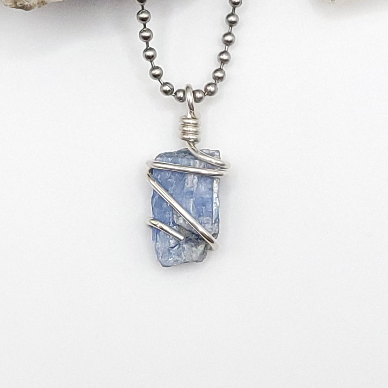 raw blue kyanite necklace in silver wire up close