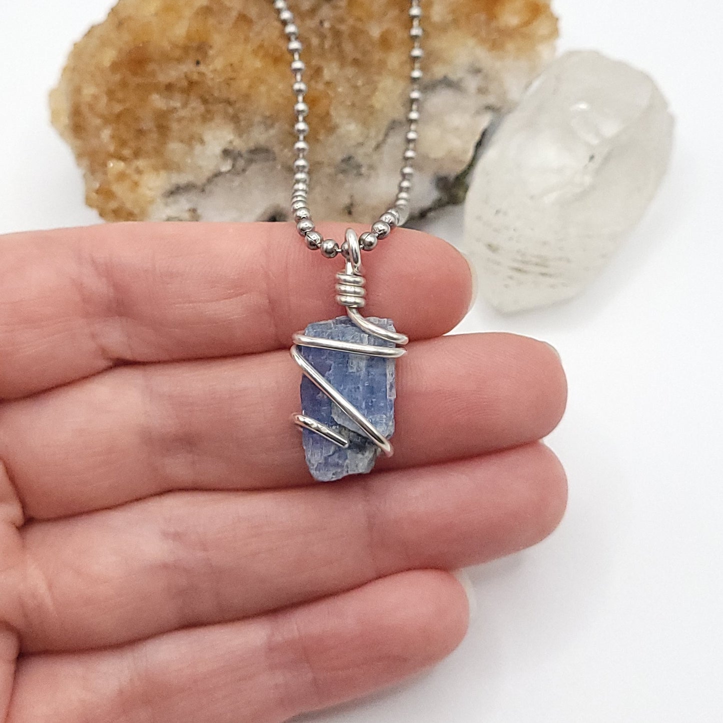raw blue kyanite necklace in silver wire in hand
