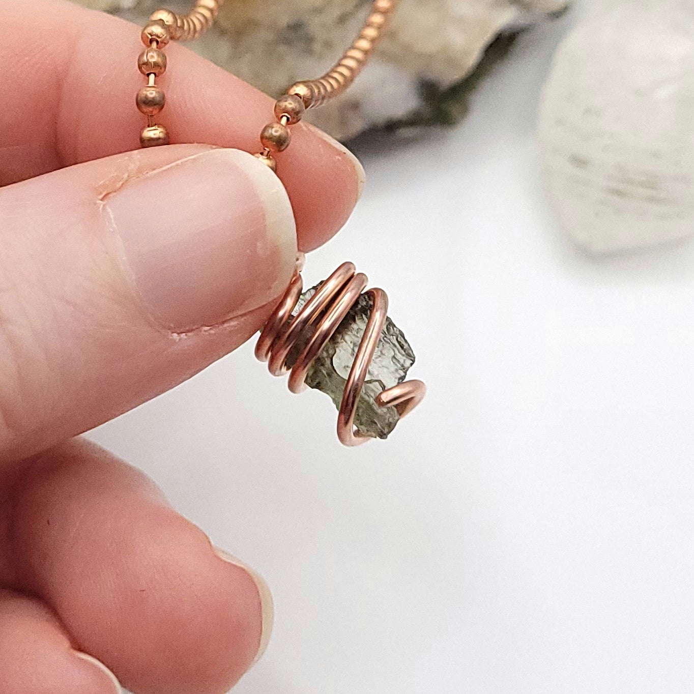 Raw Moldavite Crystal Necklace in Copper, against light