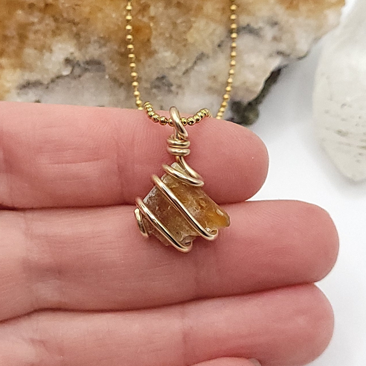 Raw Orange Kyanite Crystal Necklace in Gold, in hand