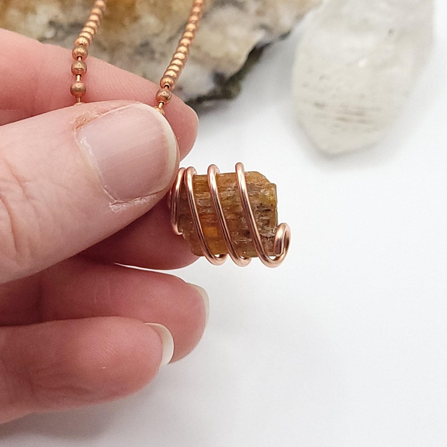 Raw Orange Kyanite Crystal Necklace in Copper, against light