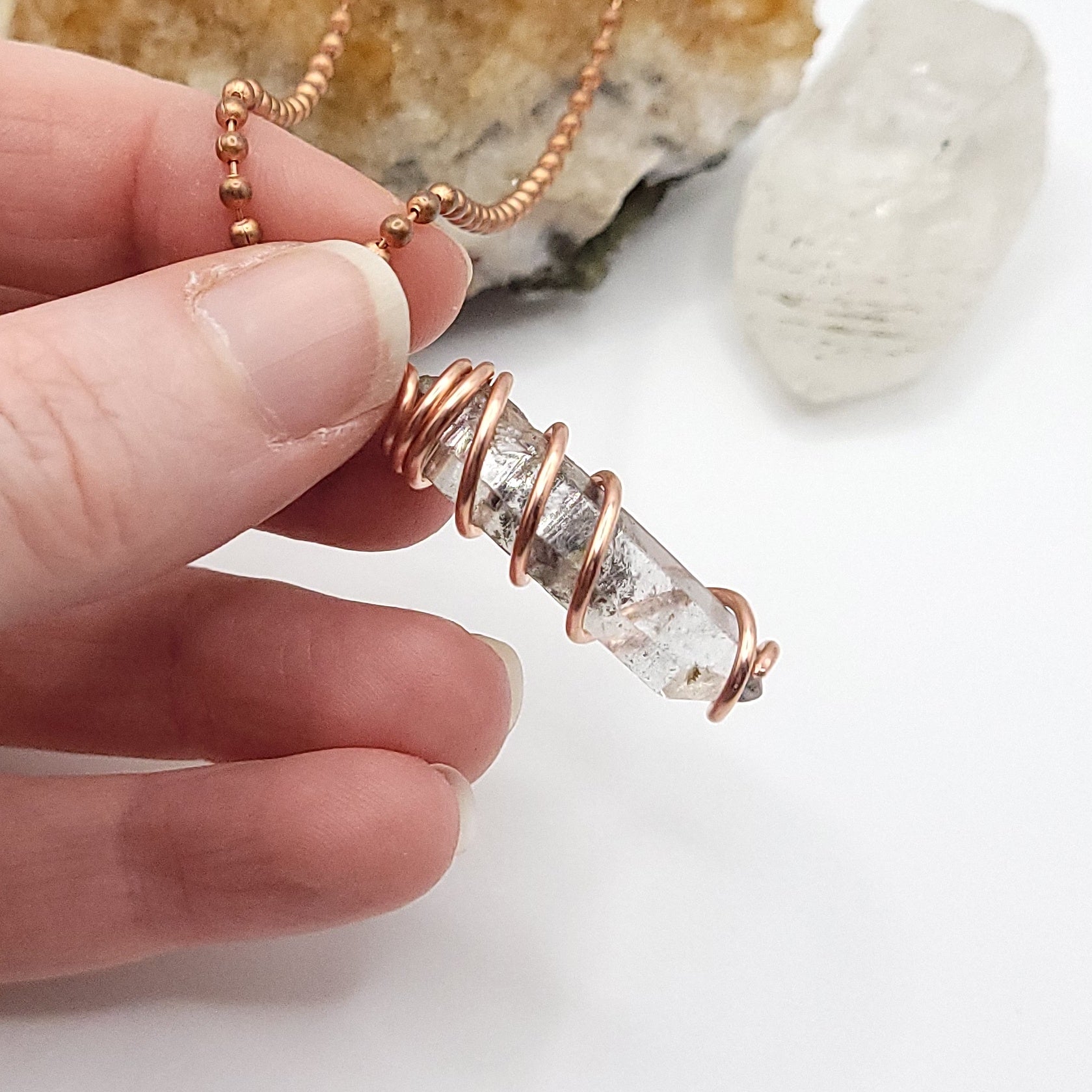 tibetan quartz necklace held by hand against white