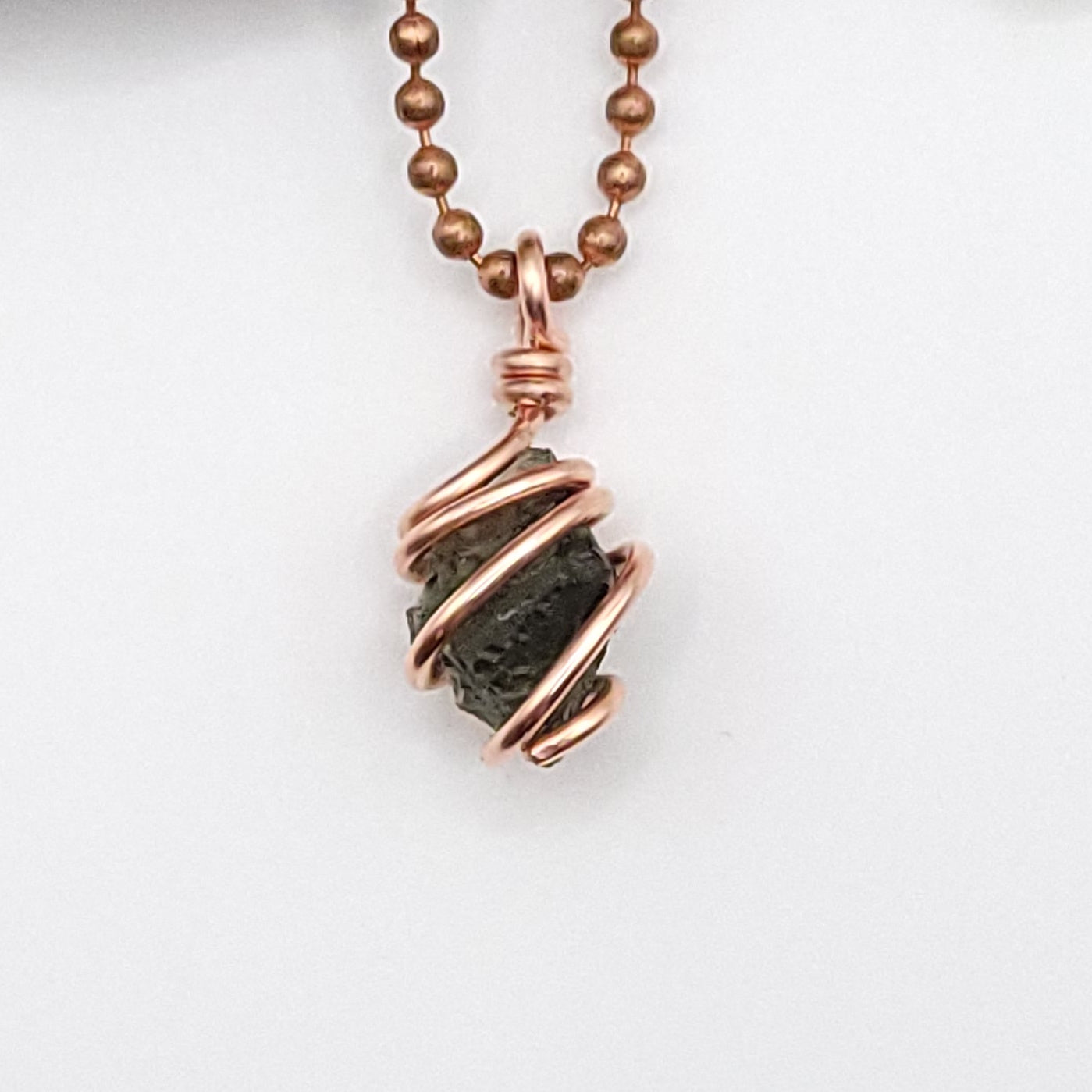 Raw Moldavite Crystal Necklace in Copper, close up on white background