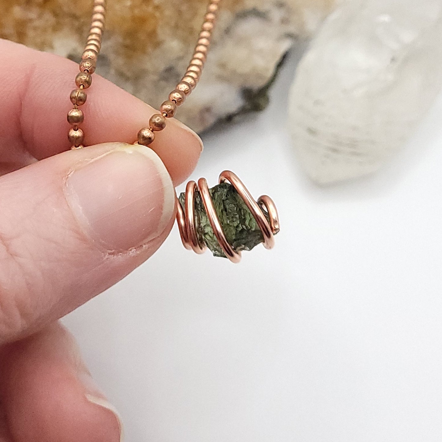 Raw Moldavite Crystal Necklace in Copper, against light