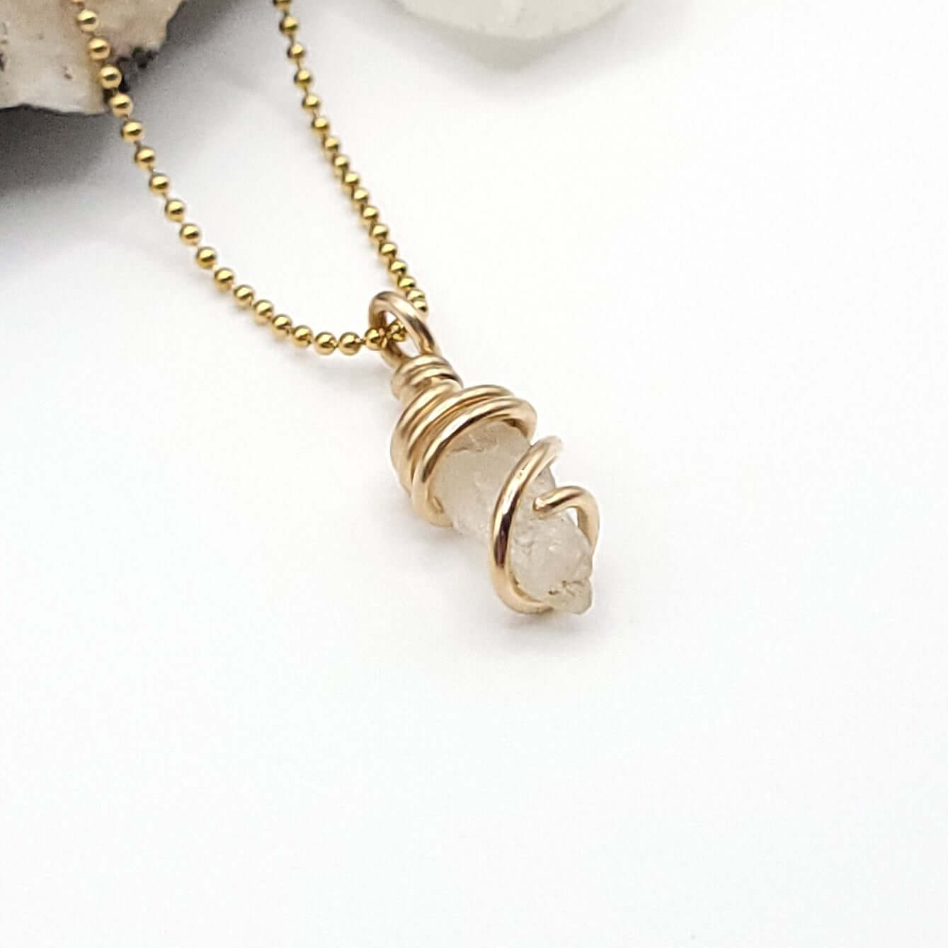 Raw Phenakite Crystal Necklace in Gold, side view on white background