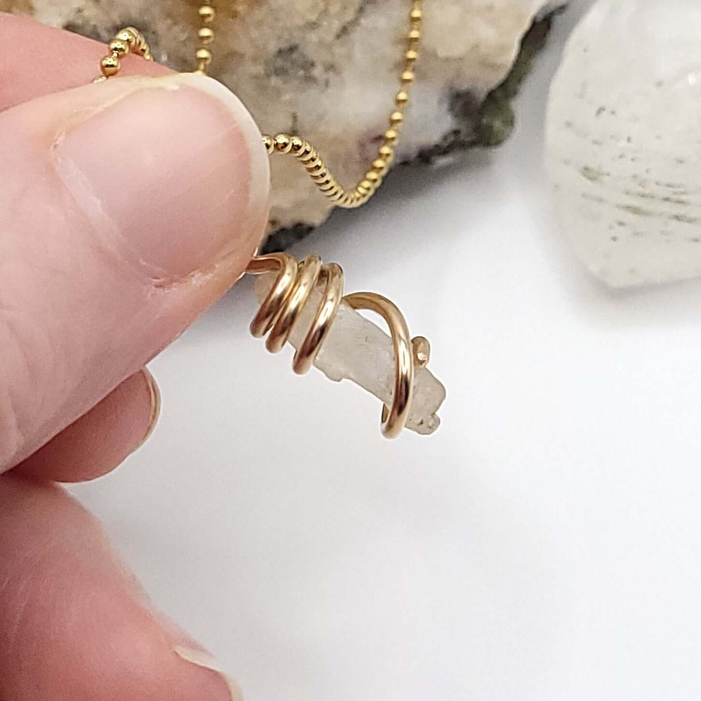Raw Phenakite Crystal Necklace in Gold, against light