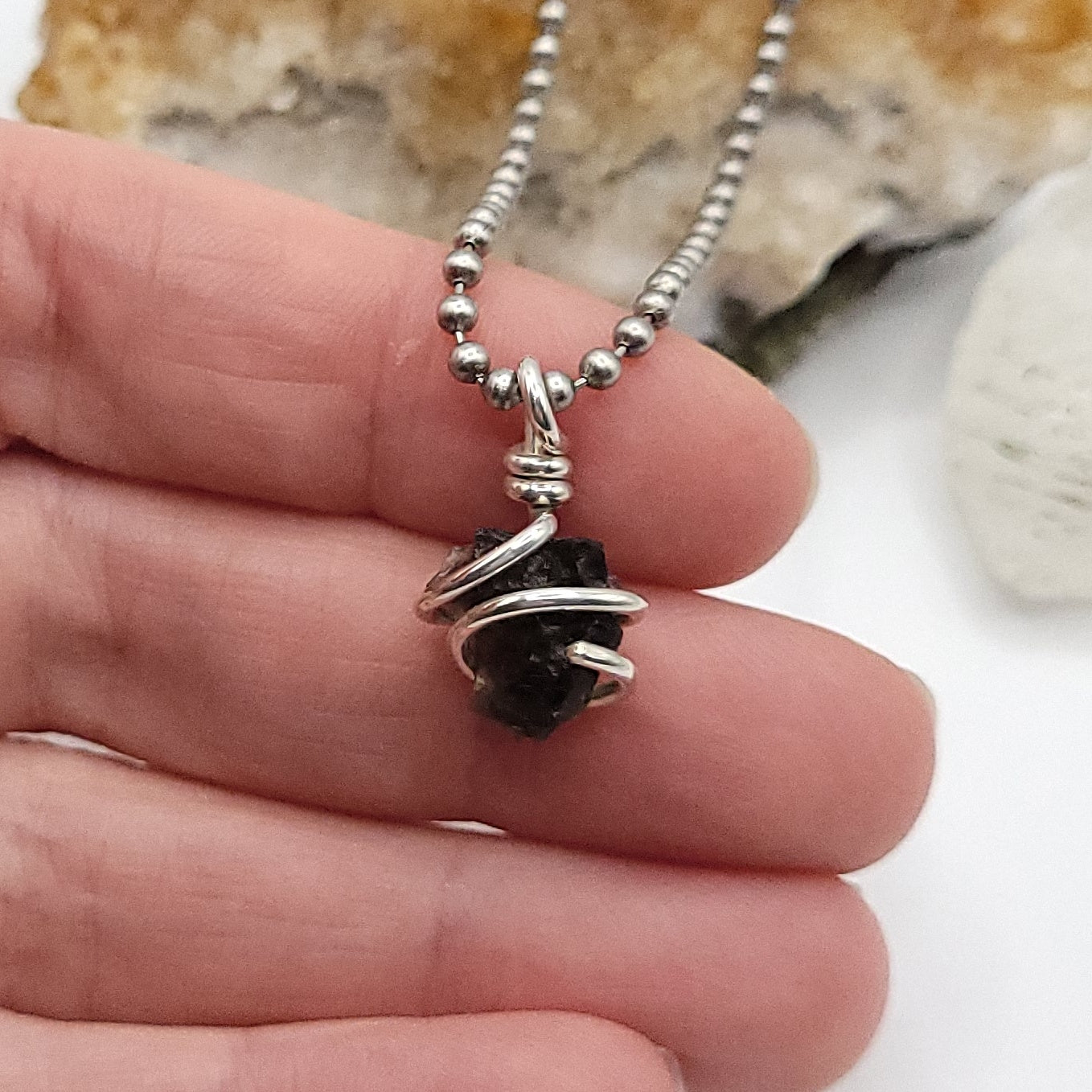 Raw Moldavite Crystal Necklace in Silver, in hand