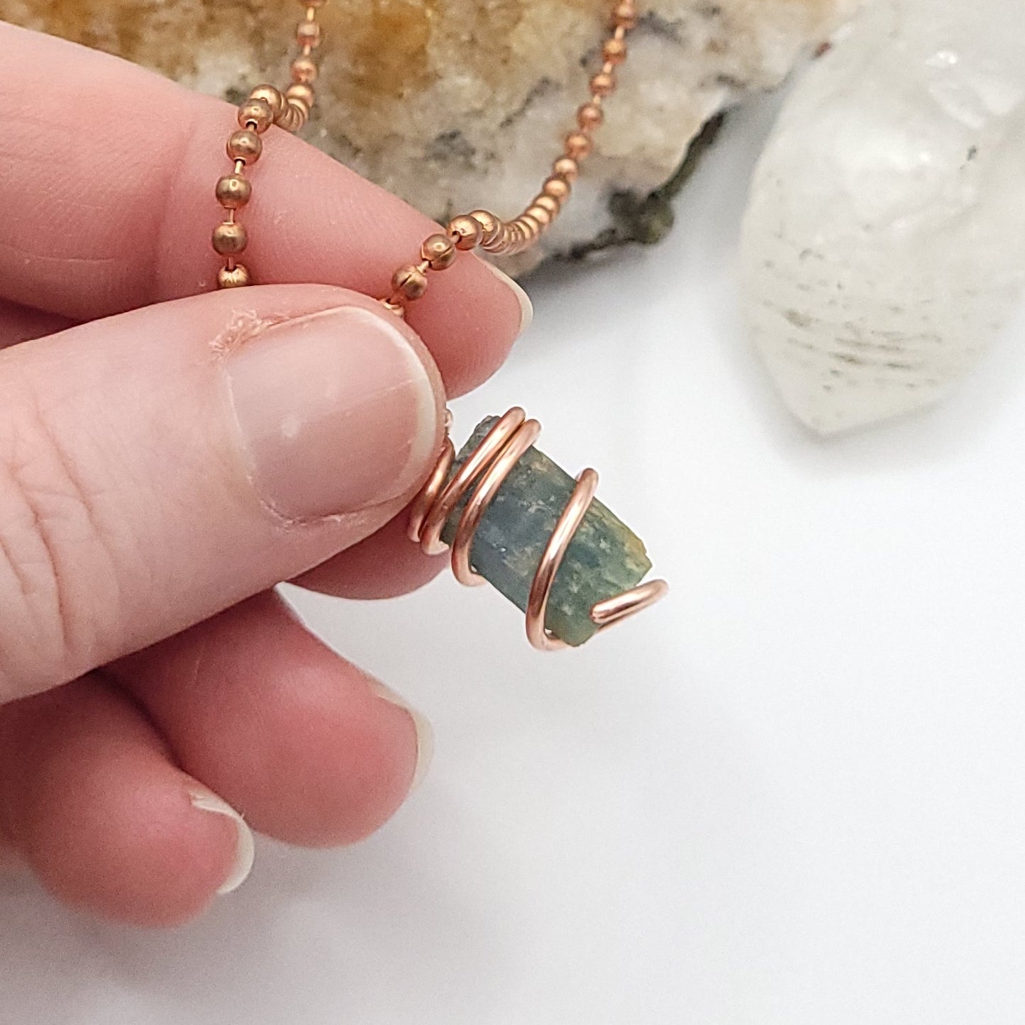 Raw Aquamarine Crystal Necklace in Copper, against light