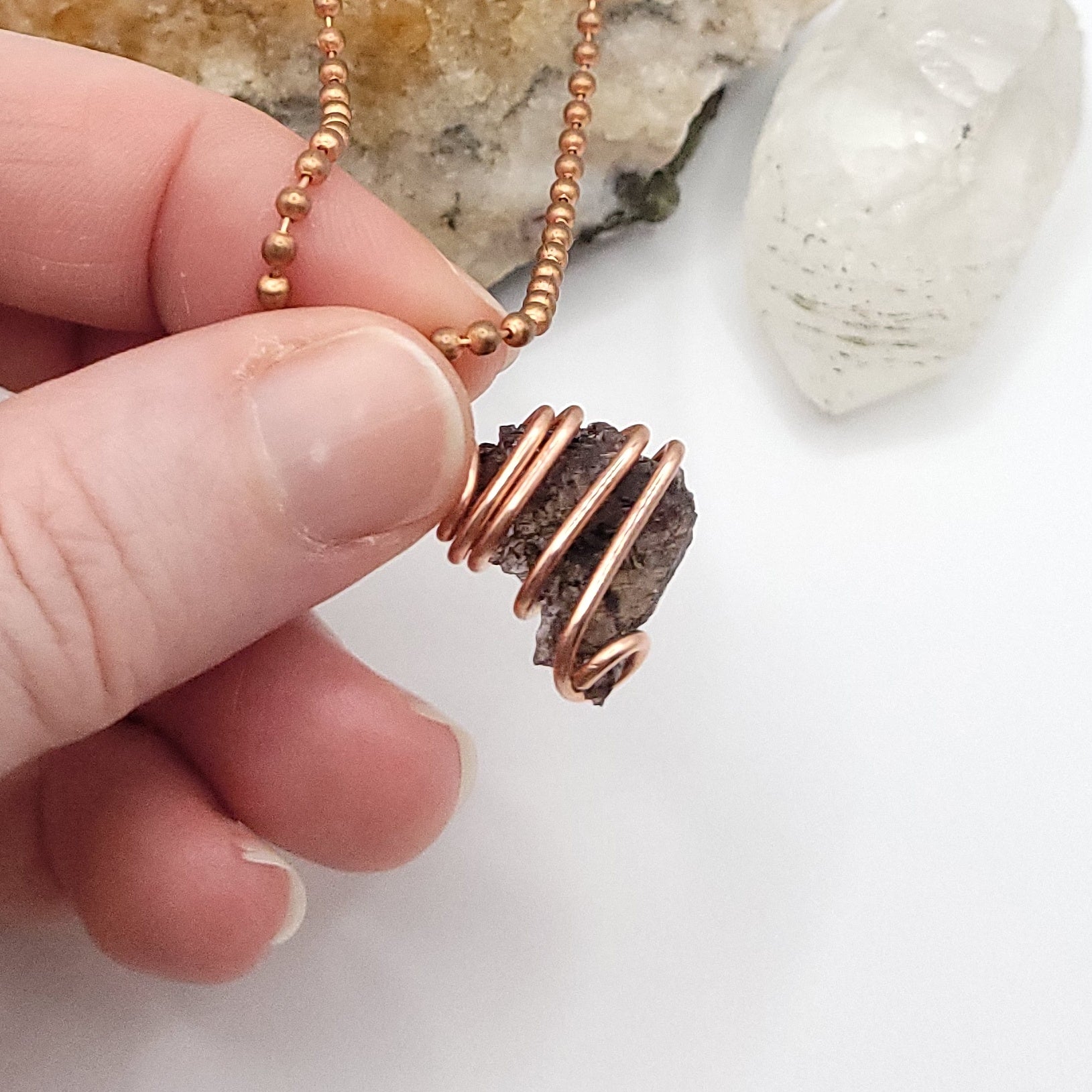 Raw Axinite Crystal Necklace in Copper, against light