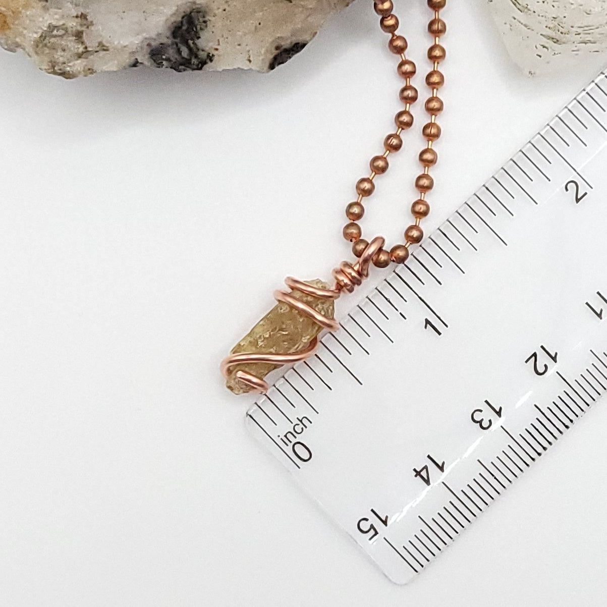 raw yellow kyanite necklace next to ruler measuring about 1 inch