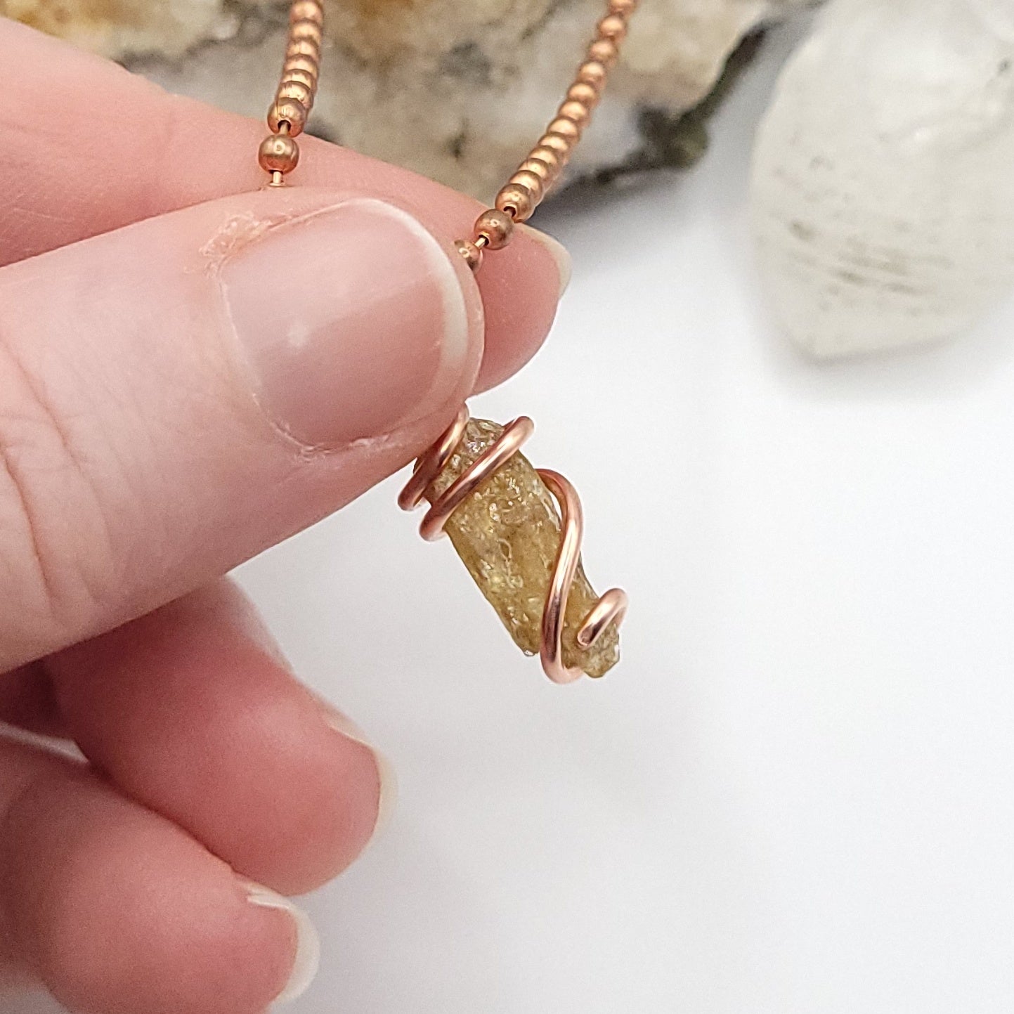 raw yellow kyanite necklace in copper side view in hand
