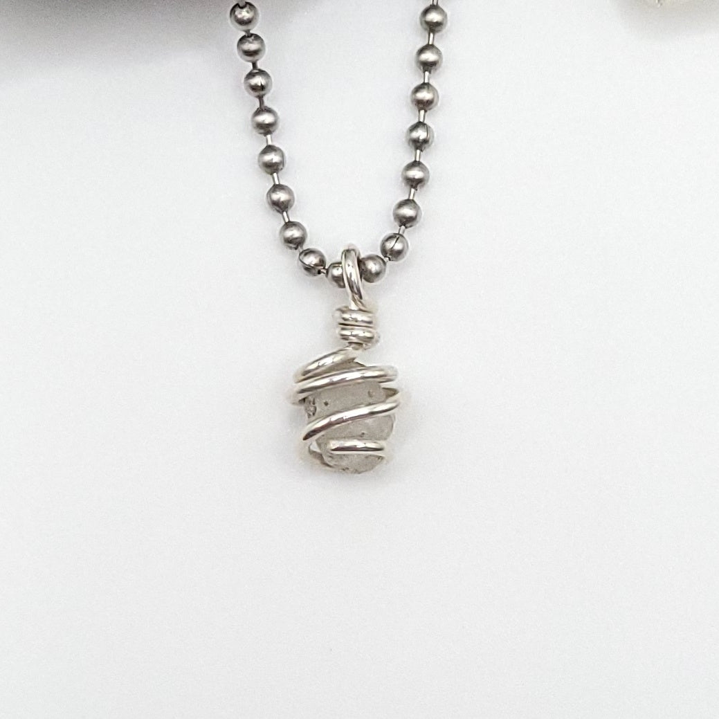 Raw Phenakite Crystal Necklace in silver, white background