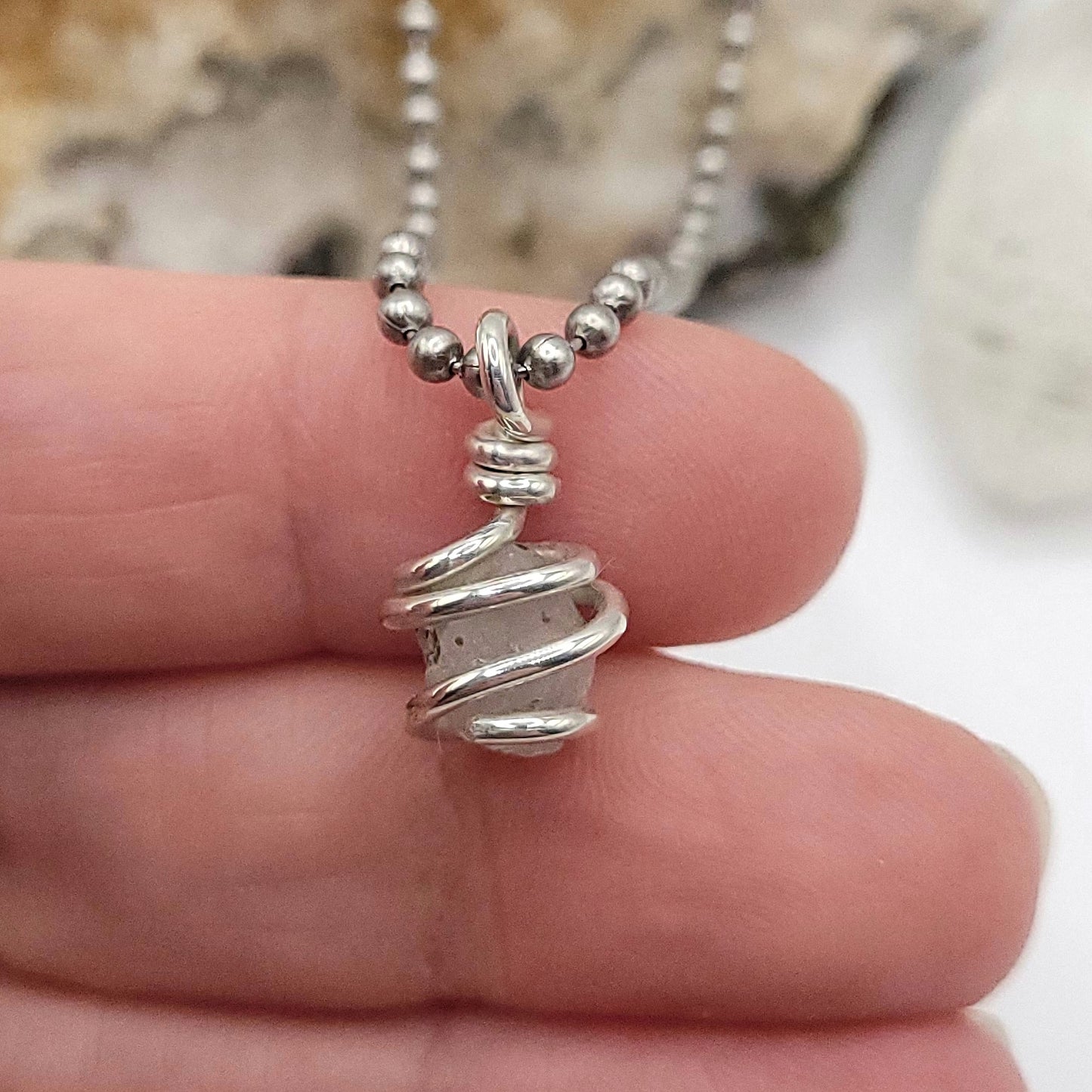 Raw Phenakite Crystal Necklace in silver, close up in hand