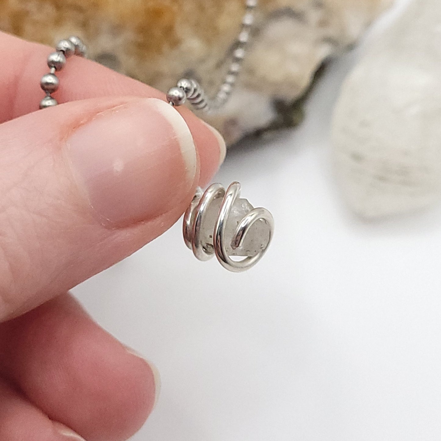 Raw Phenakite Crystal Necklace in silver, view against light