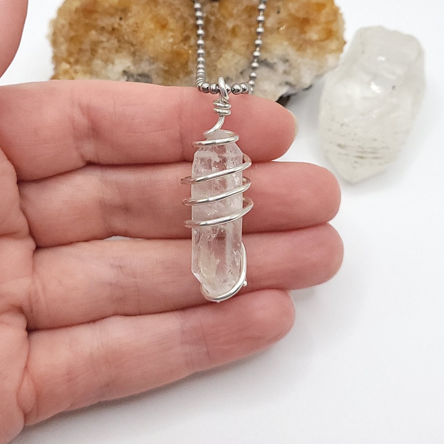 clear quartz necklace in silver in hand