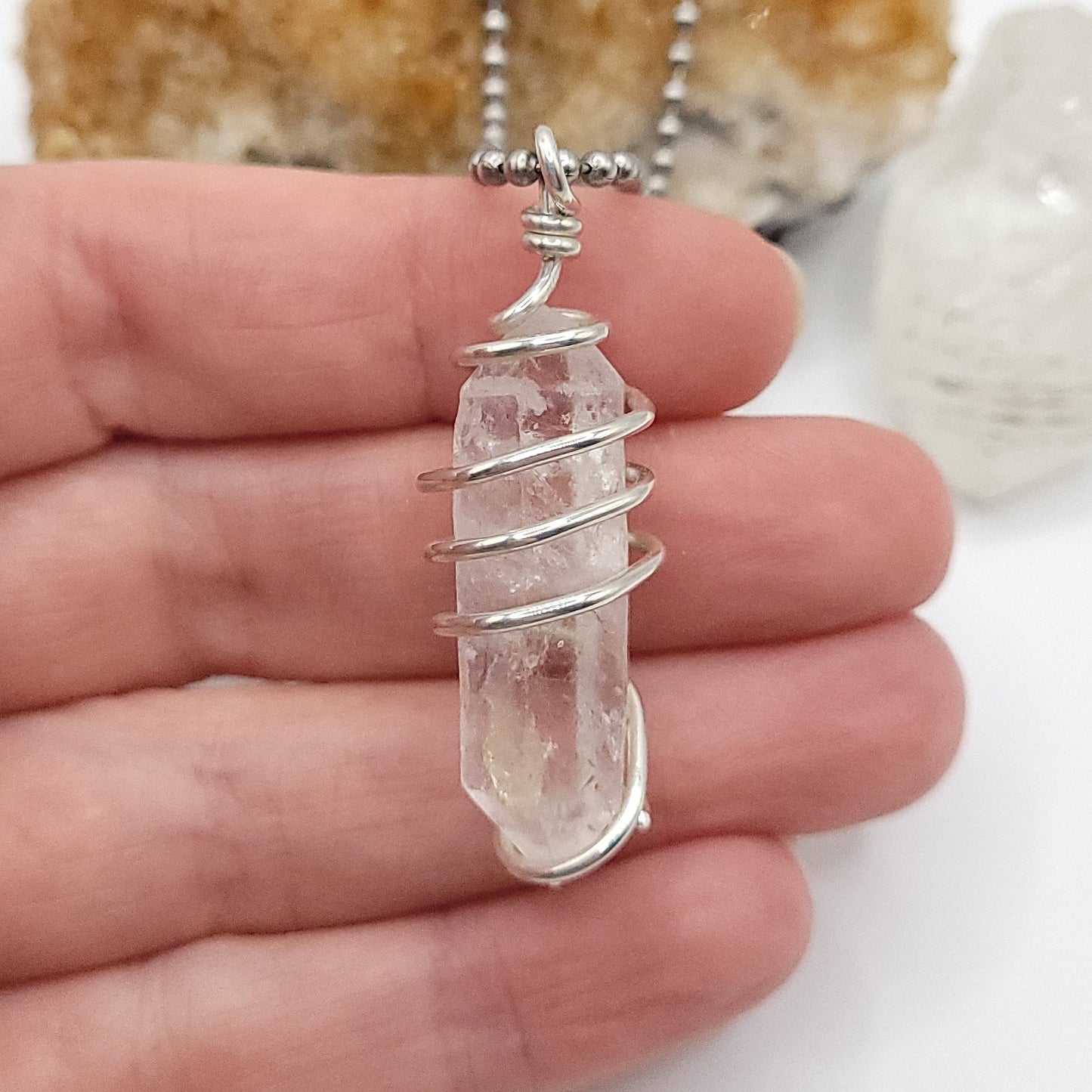 clear quartz necklace in silver in hand close up