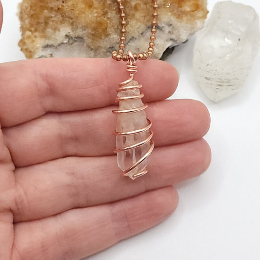 clear quartz necklace in copper in hand