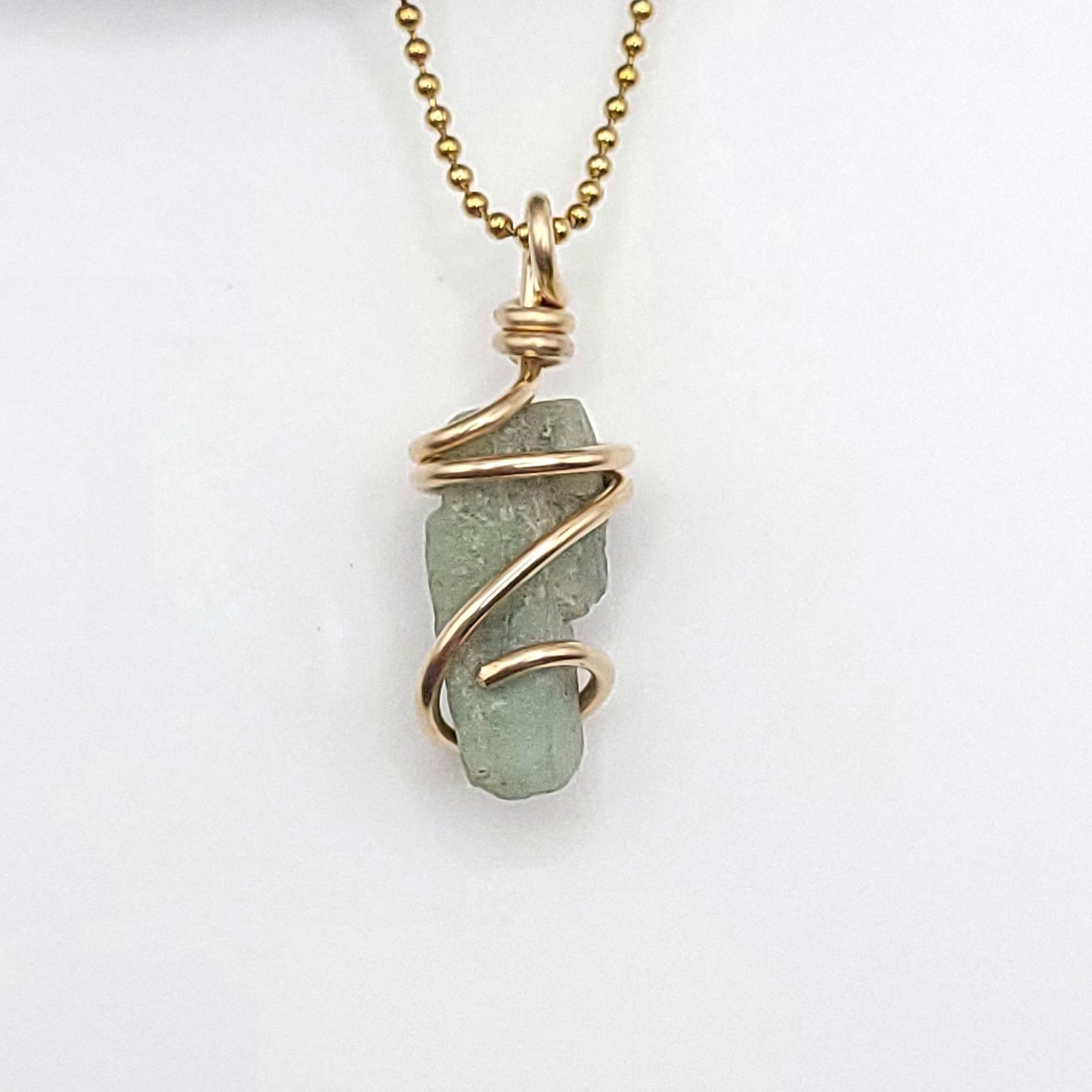 Raw Emerald Necklace wrapped in gold-filled wire for heart healing and love.