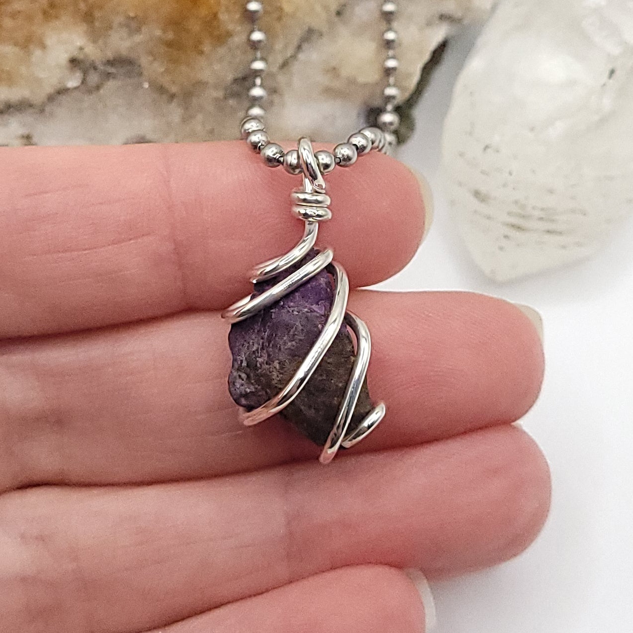 Raw Purpurite Crystal Necklace in Silver in hand