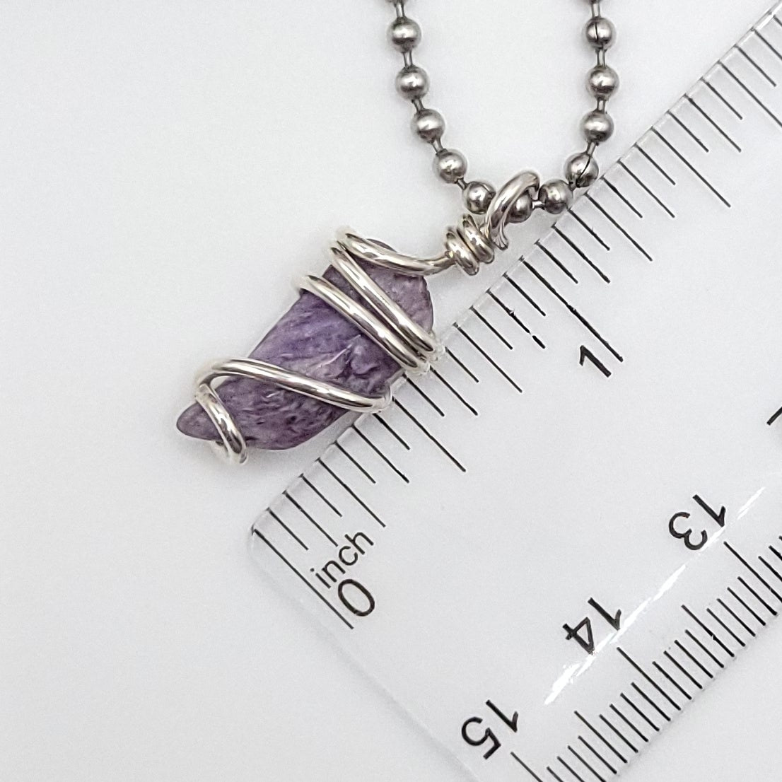 Charoite necklace in silver with a genuine Charoite stone wrapped in .925 sterling silver wire next to a ruler.