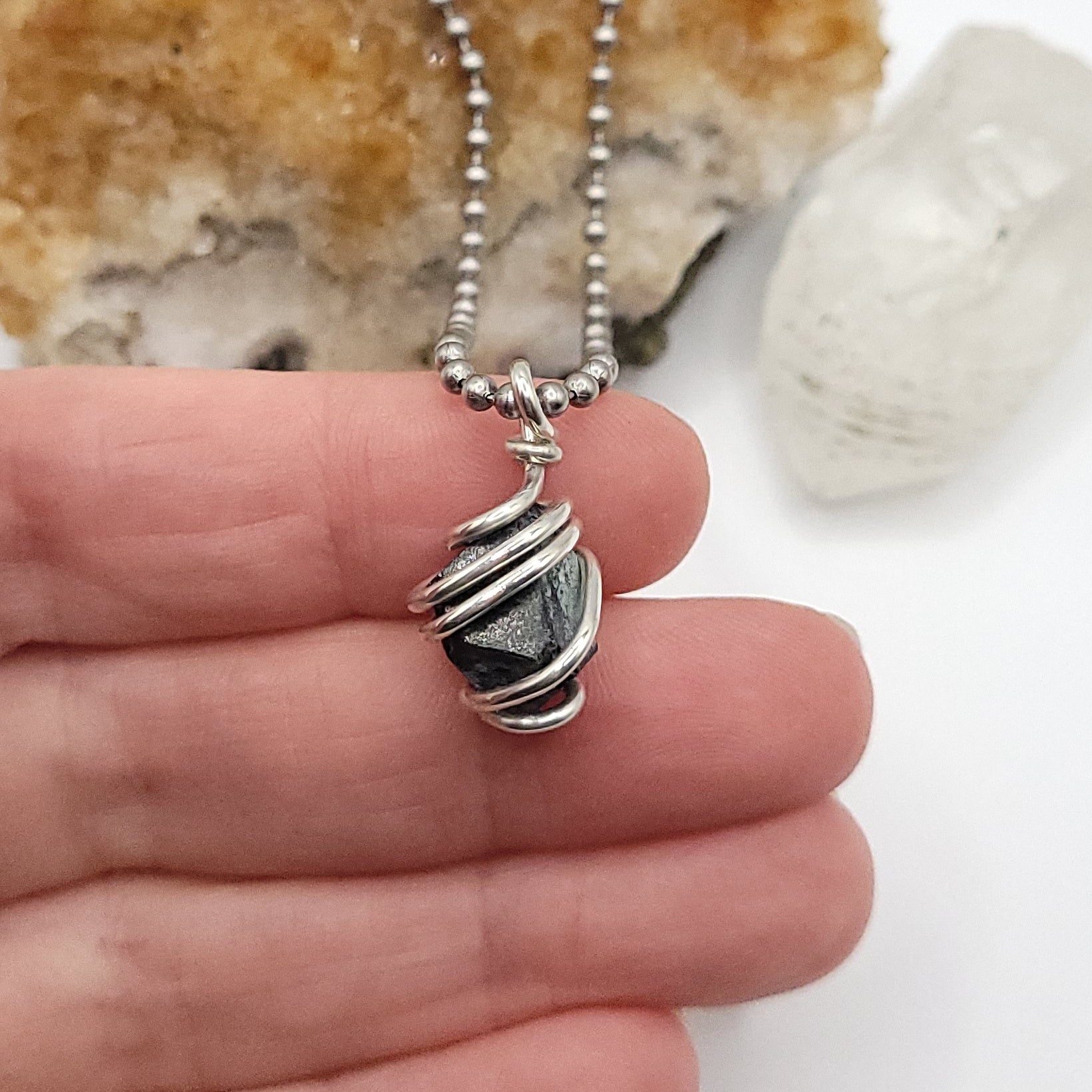 Raw Magnetite Crystal Necklace in Silver in hand