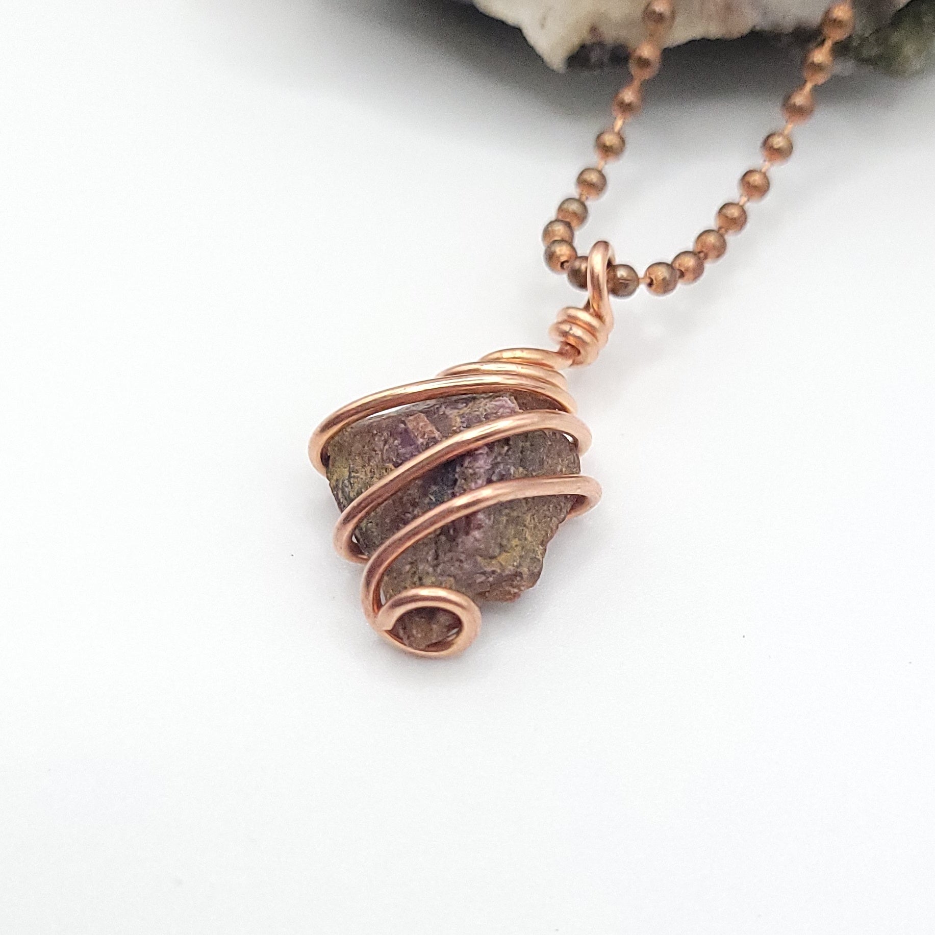 raw ruby necklace in copper side view on white background