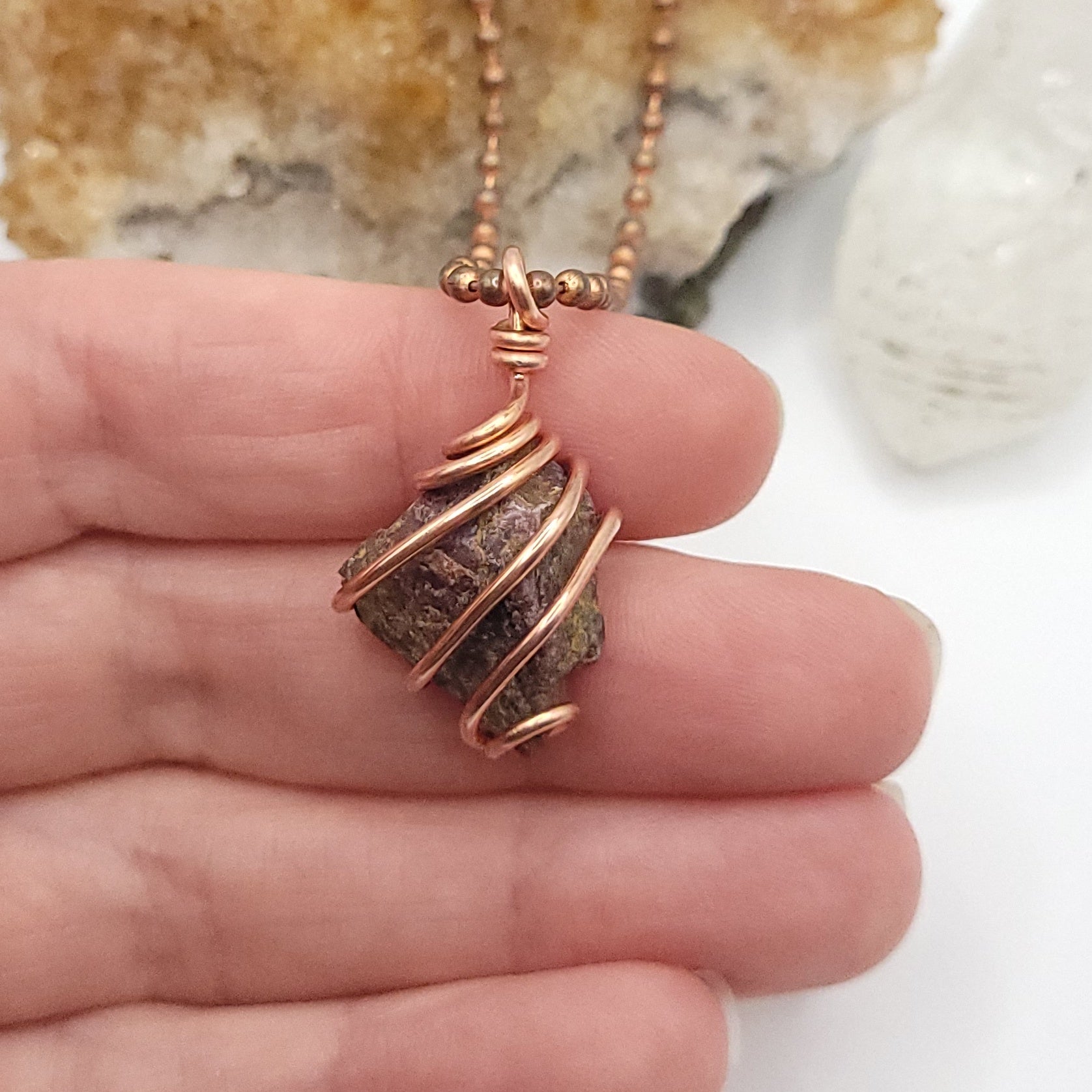 raw ruby necklace in copper in hand