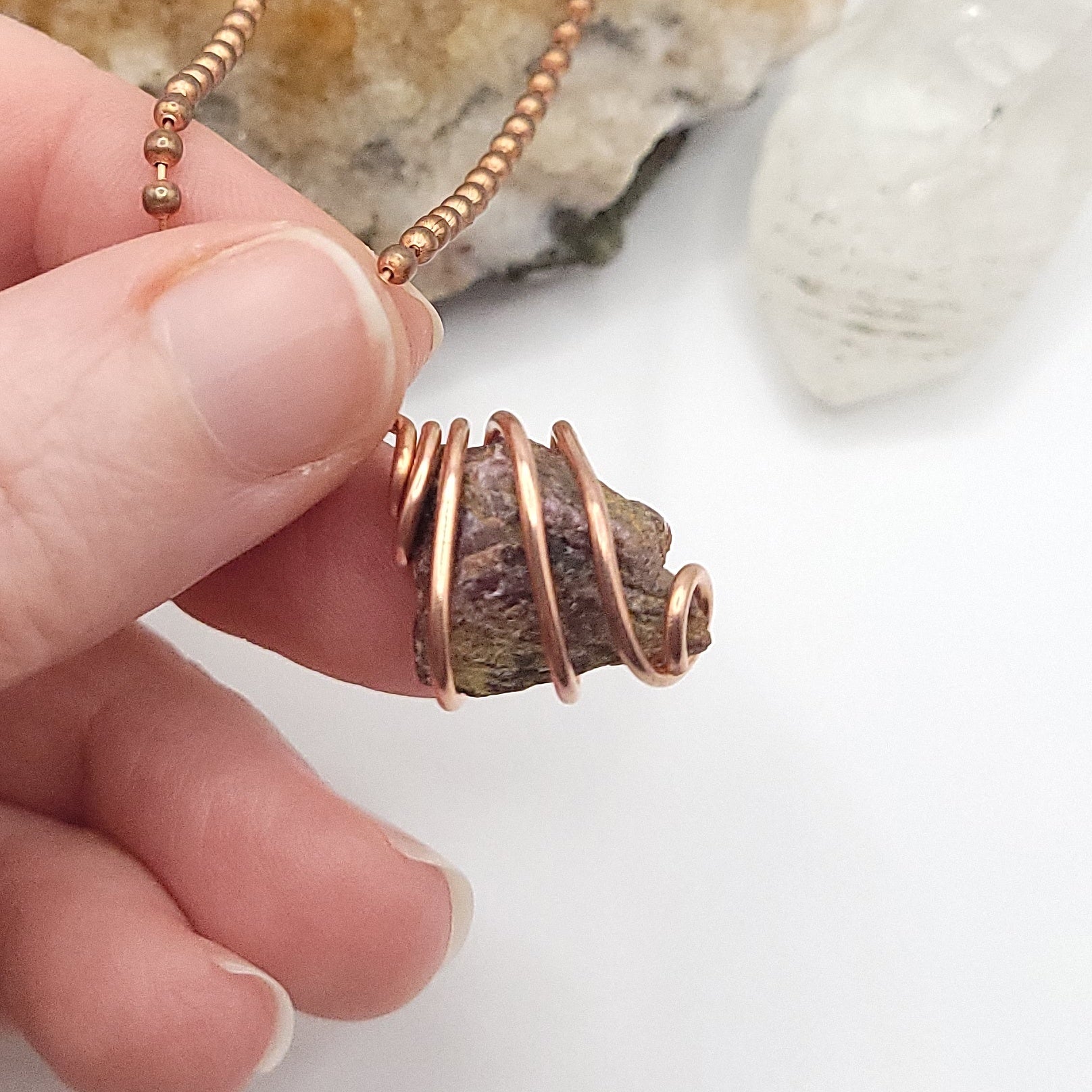 raw ruby necklace in copper side view in hand
