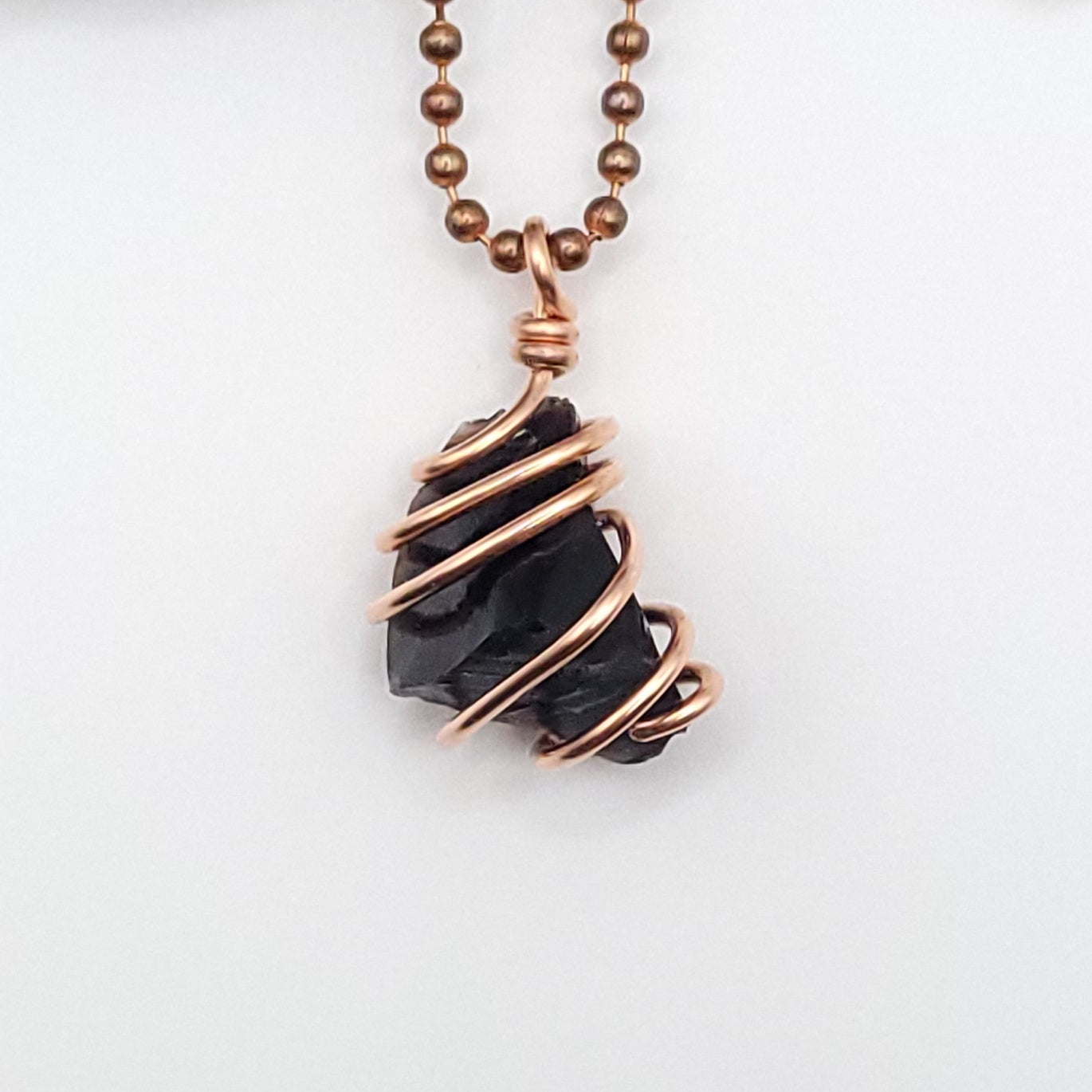 black obsidian necklace in copper on white background close up