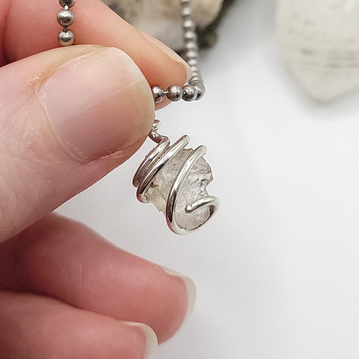 raw phenakite pendant in silver close up
