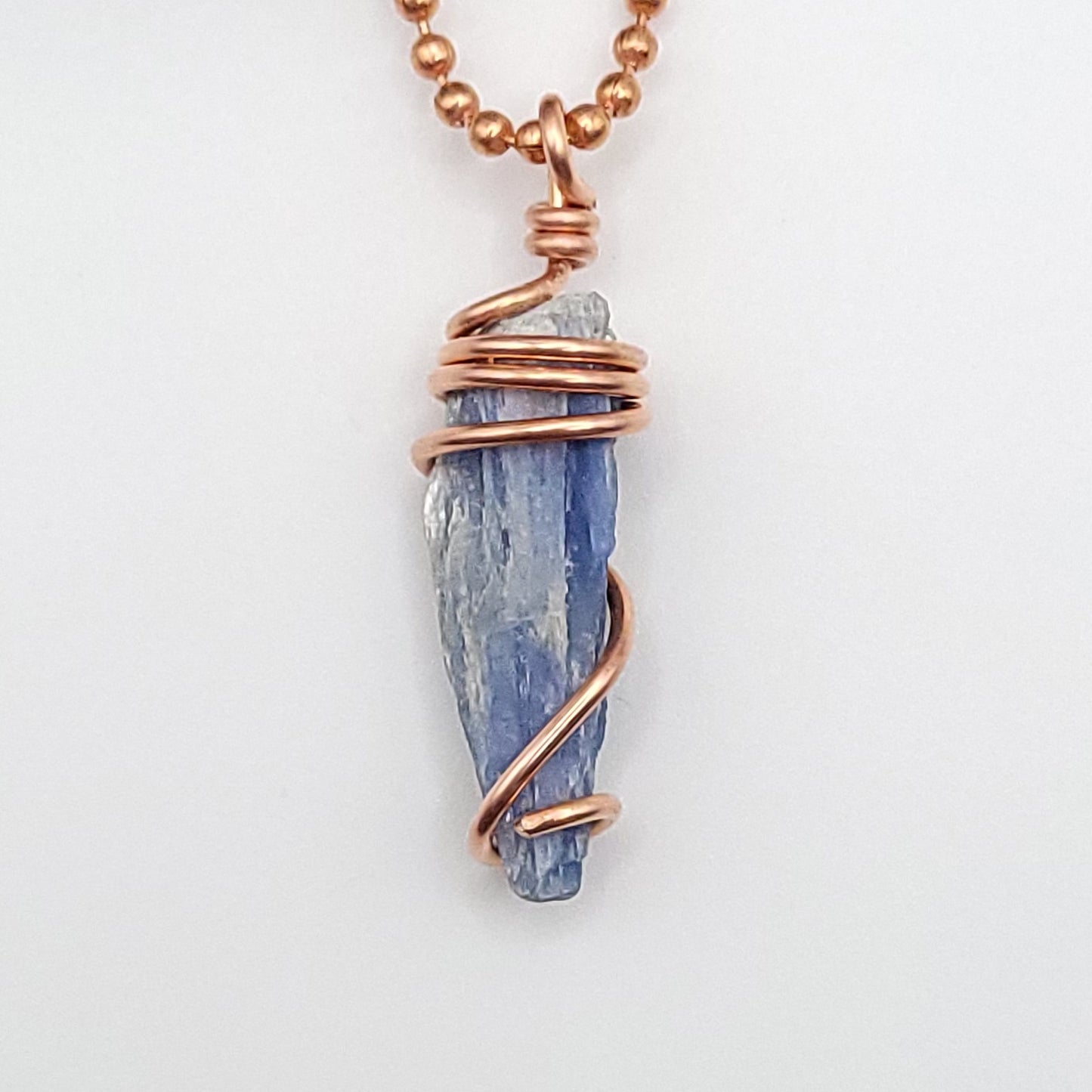 raw blue kyanite necklace in copper on white background close up