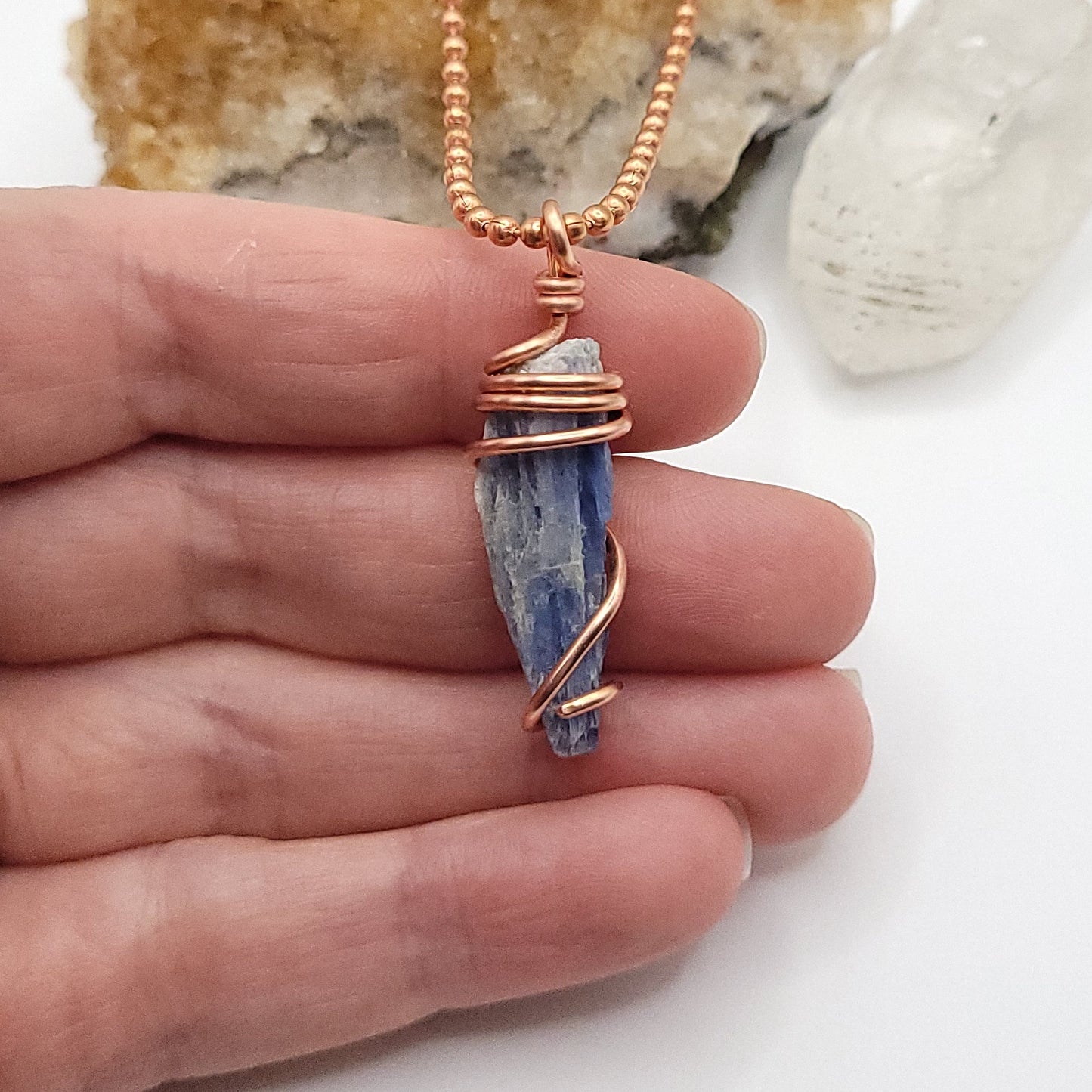 raw blue kyanite necklace in copper in hand