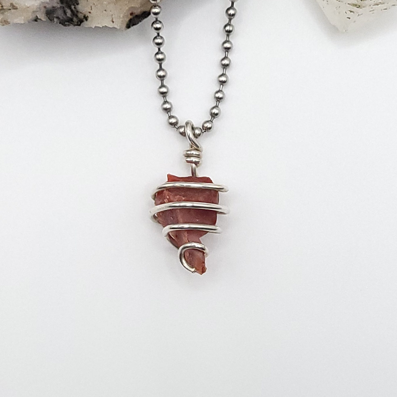 raw carnelian in sterling silver wire necklace on white backgroound