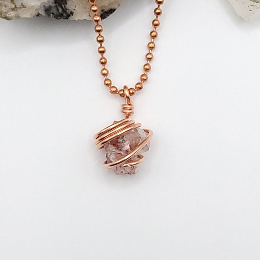 Red Apophyllite crystal necklace wrapped in copper, featuring earthy tones and natural elegance, ideal for grounding energy.