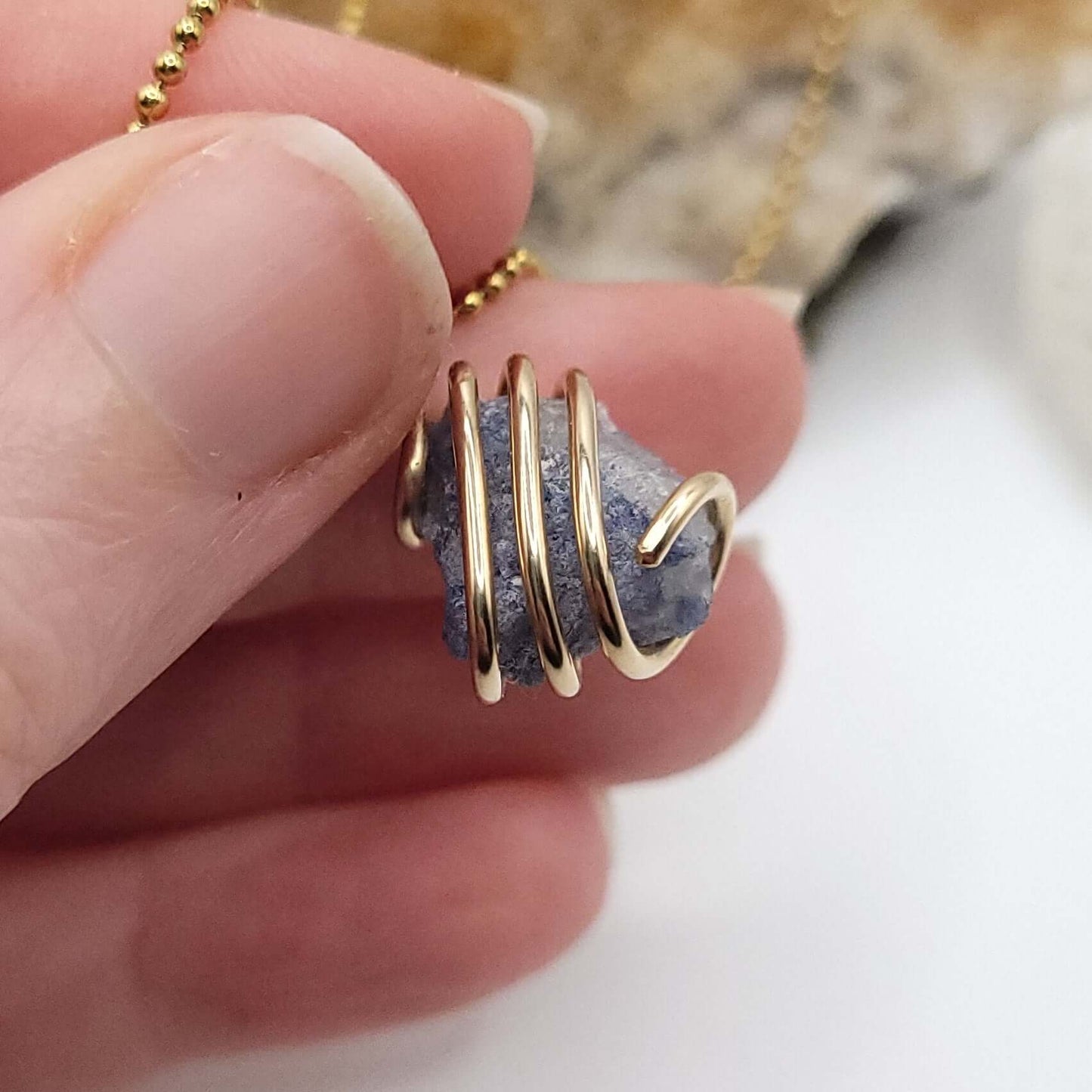 Close up of raw Dumortierite Quartz Crystal Pendant in Gold