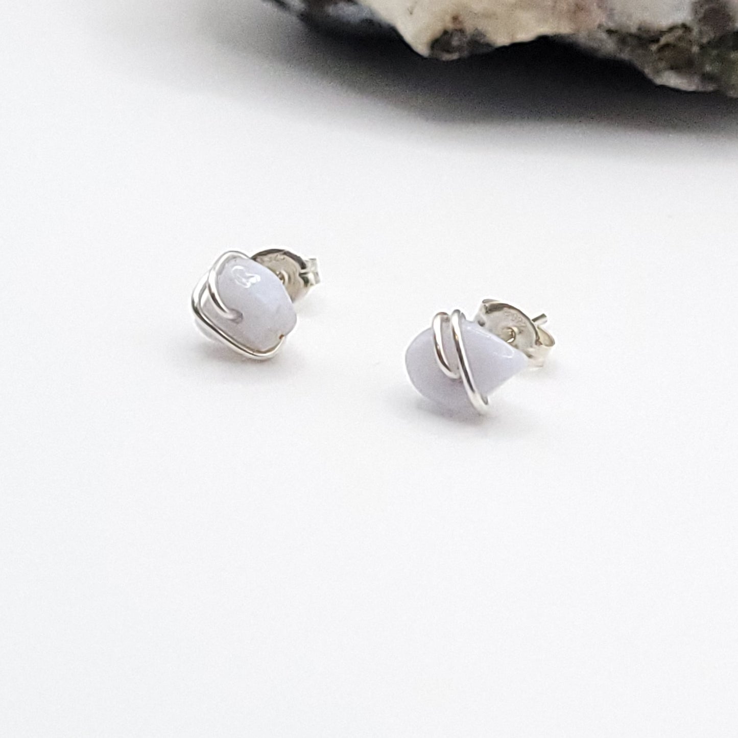 paid of blue lace agate stud earrings in sterling silver on white background