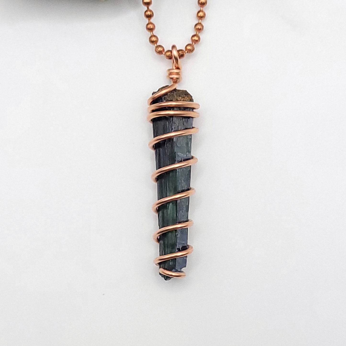 close up of vivianite pendant in copper wire
