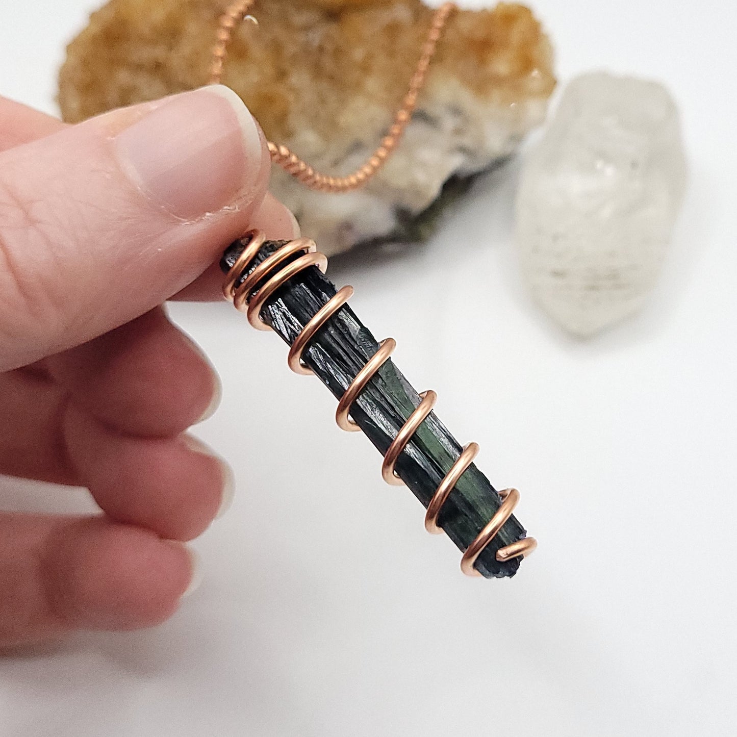 side view of vivianite pendant in copper wire