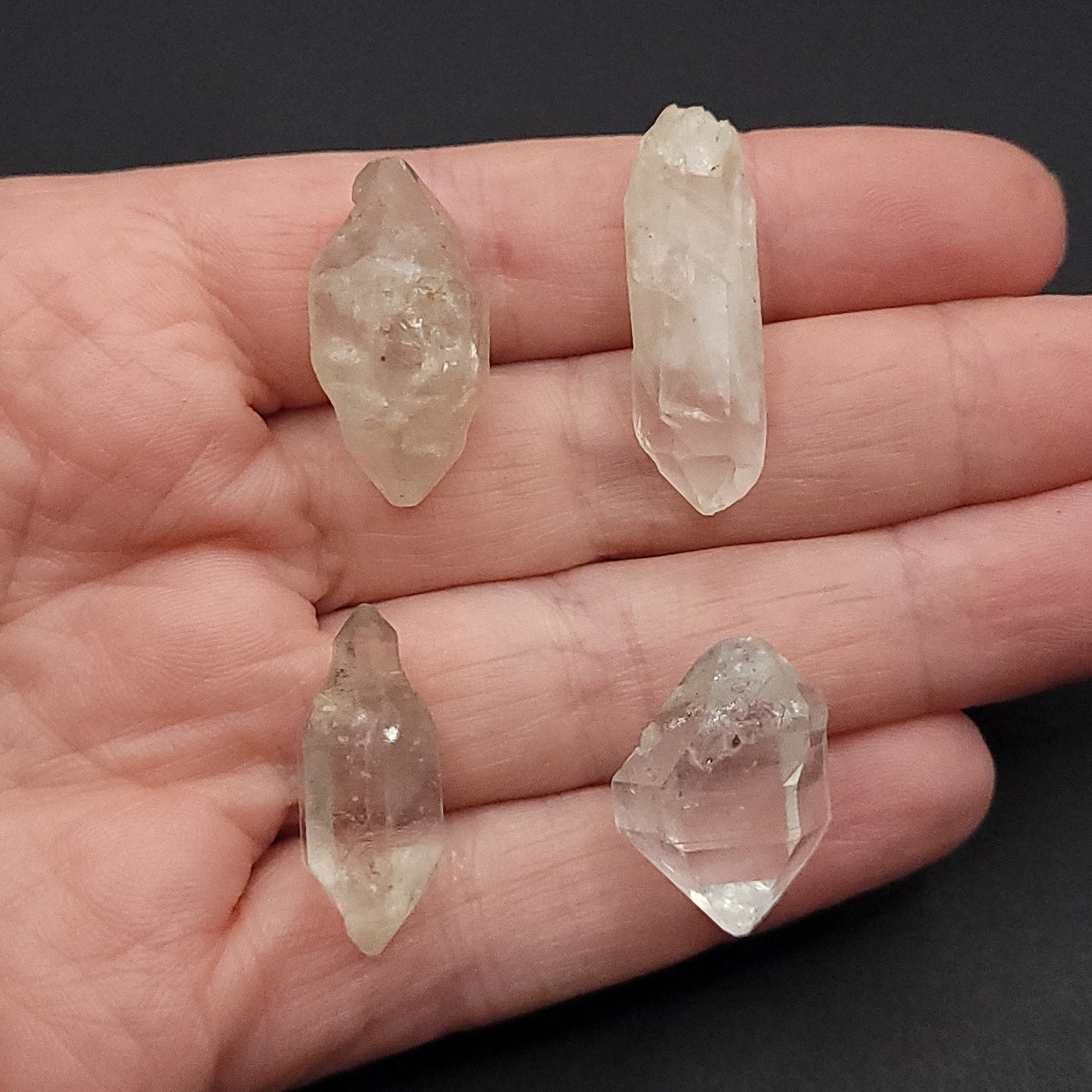 four clear quartz stones to choose from in hand