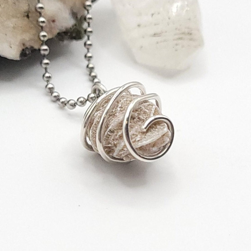 Silver wire-wrapped desert rose selenite pendant necklace on a white background side view