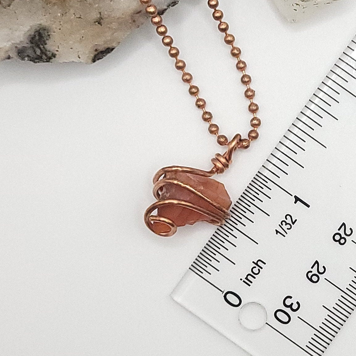 Raw Carnelian Crystal Necklace in Copper next to ruler measuring about  1 inch